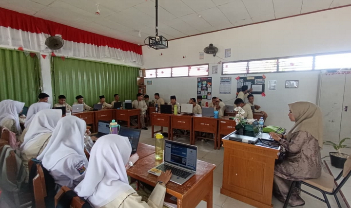 Suasana kegiatan belajar mengajar siswa dan guru di dalam kelas menggunakan platform digital di SMPN 17 Kota Padang.